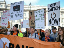 Un grupo de personas sostiene pancartas durante una "protesta de emergencia" organizada por el grupo de acción cívica PauseAI UK