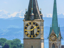 Las torres de las iglesias de San Pedro y de Fraumünster, una imagen habitual de Zúrich (Suiza), frente al lago Zúrich y los Alpes al fondo