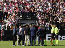 El árbitro José María Sánchez Martínez (c) habla con miembros de ambos equipos antes de comunicar la suspensión definitiva del partido entre el Rayo Vallecano y el Athletic