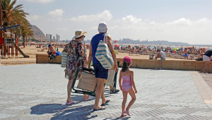 Unos turistas se dirigen a una playa de Alicante. En 2021 solo llegaron a España un 37 % de los turistas extranjeros que nos visitaron en 2019