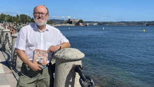 Santiago Juega posa en el puerto coruñés con un ejemplar de su libro 'Periplo al Moluco. La Casa de Contratación de Especiería A Coruña 1522-1529'