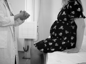 Médico pasando consulta a una mujer embarazada