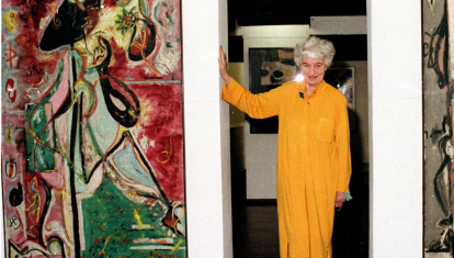 La coleccionista de arte Peggy Guggenheim posa con cuadros entre los primeros cuadros de Jackson Pollock
