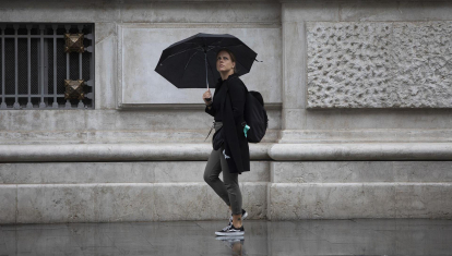 Un hombre camina bajo la lluvia con un paraguas