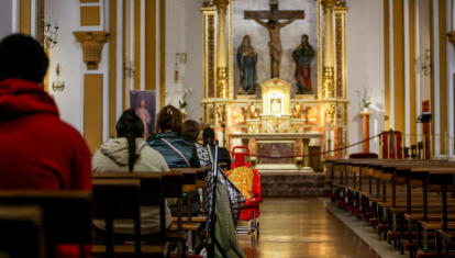 Varias personas sentadas en los bancos de una Iglesia en Madrid