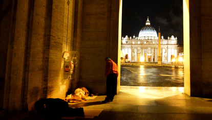 Un voluntario de la asociación City angels habla con una persona sintecho en el Vaticano