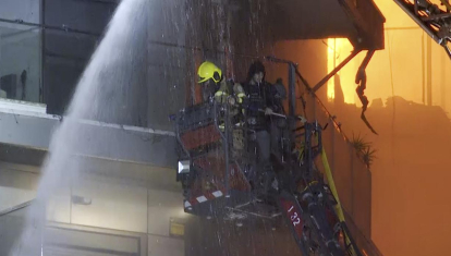 Los bomberos rescatan a dos personas del incendio provocado en el edificio de 14 plantas de Valencia