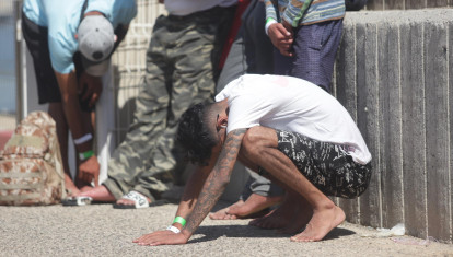 Un inmigrante rescatado se apoya en el suelo durante el rescate de diez menores, de una patera en aguas de Barbate