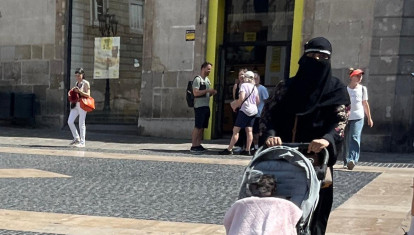 Una mujer camina por la plaza Sant Jaume de Barcelona con un velo integral