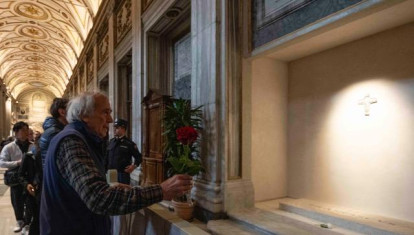 Un hombre lleva una rosa a la tumba del Papa Francisco en la basílica de Santa María la Mayor
