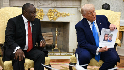 El presidente estadounidense Donald Trump muestra una fotografía de su reunión con el presidente sudafricano Cyril Ramaphosa en la Oficina Oval de la Casa Blanca en Washington, D.C.
