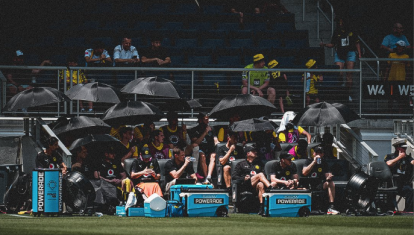 Los futbolistas del Borussia Dortmund se protegen del sol en el banquillo