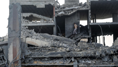 Un hombre palestino se abre paso entre los escombros de un edificio alcanzado por un ataque israelí en el campo de refugiados de Bureij, en el centro de la Franja de Gaza,