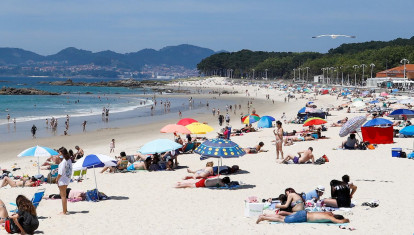 Varias personas se bañan y toman el sol en la playa de Samil, en Vigo, Pontevedra