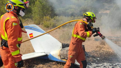 Imagen de los bomberos apagando el fuego provocado en el accidente de avioneta en Requena, Valencia