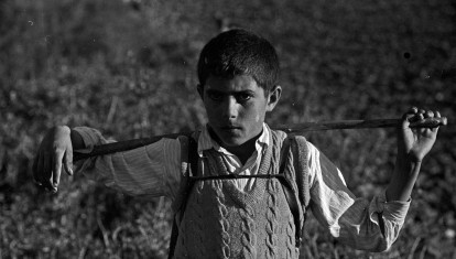 Un niño en la celebración de una partida de caza por un grupo de cazadores en un pueblo de España en 1959.