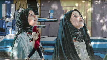 Una mujer iraní pasa junto a un mural en una calle de Teherán, Irán, el 20 de octubre de 2025