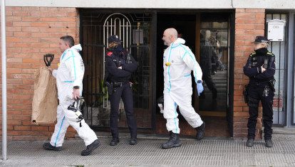 Policías judiciales en la puerta del edificio de Manlleu (Barcelona) donde ocurrió la tragedia