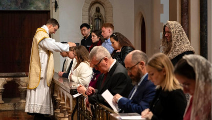 Feligreses acuden a recibir la eucaristía en una misa dominical solemne (no tridentina) en latín en el Oratorio