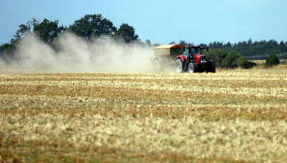 Un agricultor aplica fertilizantes con el tractor