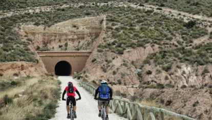 Unos ciclistas atravesando los túneles de la Vía Verde de Maigmó, Alicante