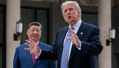 El presidente estadounidense Donald Trump (derecha) gesticula mientras posa para las fotos con el presidente chino Xi Jinping