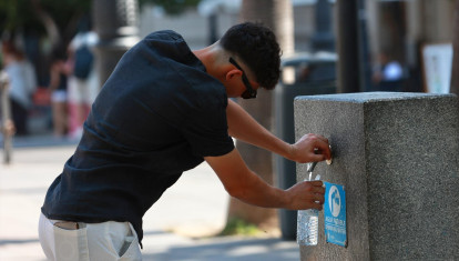 Una persona se refresca en una fuente