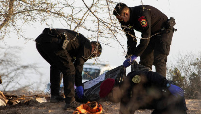 Agentes de policía y equipos forenses trabajan en el lugar donde se estrelló una avioneta en el distrito de Vista Alegre, en Nazca (Perú)