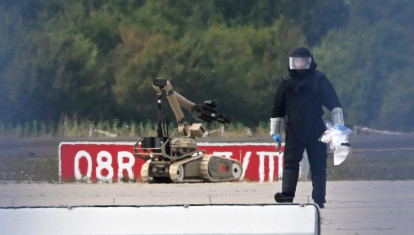Un técnico forense trabaja junto a un robot desactivador de explosivos cerca de un avión de carga ucraniano en el aeropuerto de Leipzig-Halle, en Schkeuditz (este de Alemania)