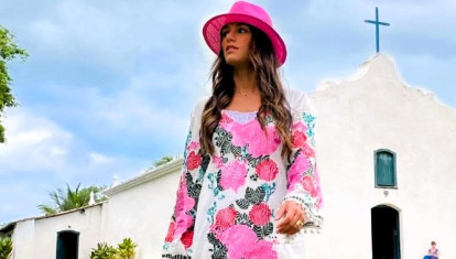 Una mujer, con vestido largo, frente a la iglesia