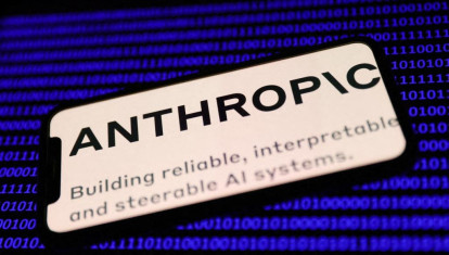 El logotipo de Anthropic en la pantalla de un teléfono y código binario en la pantalla de un ordenador portátil