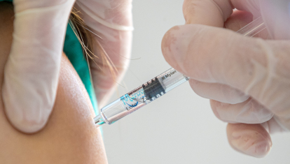 Una enfermera administra una dosis de vacuna de la gripe