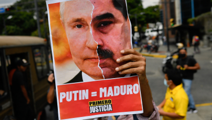 Un miembro del partido opositor Primero Justicia sostiene una pancarta que muestra el rostro del presidente ruso, Vladimir Putin, y el presidente venezolano, Nicolás Maduro