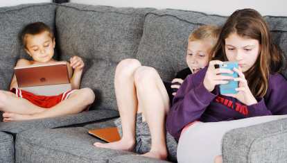 Niños jugando con dispositivos tecnológicos
