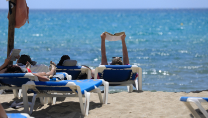 Varias personas leen y toman en sol en Mallorca