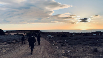 Marcha de endurecimiento de mandos legionarios en Melilla; al fondo, la valla con Marruecos