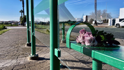 Un ramo de flores en una parada de autobús de Gerena (Sevilla), en el entorno donde ayer fue apuñalado mortalmente un menor de 17 años a la salida de su instituto