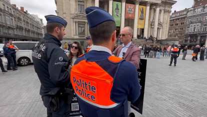 El momento en que la policía Belga rodea a los dos manifestantes antes de detenerlos