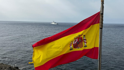 La bandera de España ondea en la isla de Alborán; al fondo, el buque de acción marítima Furor de la Armada española