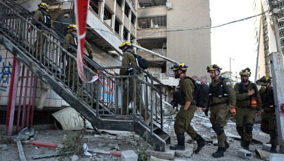 Los equipos de emergencia israelíes entran en un edificio alcanzado por un ataque iraní en Haifa