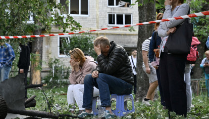 Residentes reaccionan mientras los rescatistas ucranianos realizan labores de búsqueda y rescate en un edificio residencial gravemente dañado tras el ataque con misiles rusos en Kiev