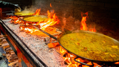 Imagen de unas paellas cocinadas a leña en el restaurante Casa Carmela de Valencia