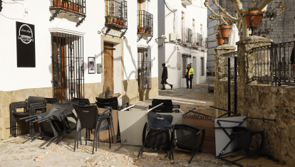 GRAZALEMA (CÁDIZ), 16/02/2026.- Sillas y mesas apiladas en una calle de Grazalema este lunes. Un primer grupo de vecinos desalojados hace 11 días por el temporal en Grazalema (Cádiz) ha podido volver a sus hogares a partir de las 16:05 horas de este lunes, cuando la Guardia Civil ha permitido el acceso a una treintena de vehículos al municipio. EFE/ Jorge Zapata