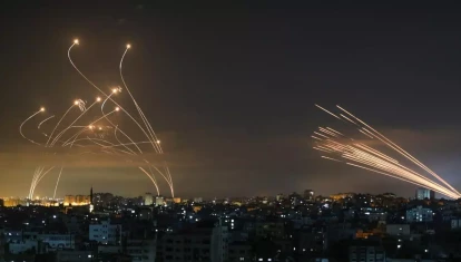 La Cúpula de Hierro israelí (izquierda), desplegada para detener un ataque de misiles lanzado por Hamas desde Gaza (derecha), en 2021