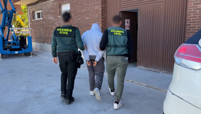 Imagen de dos agentes con el joven detenido por varios robos en naves industriales de Valencia.