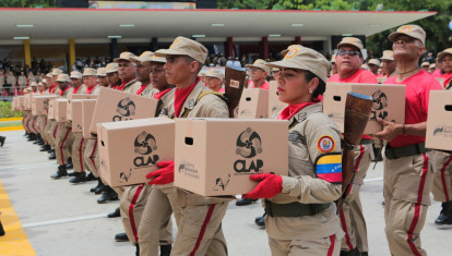 Handout photo released by Miraflores presidential palace press office showing members of the Venezuelan militia holding boxes of Local Committee for Supply and Production (CLAP) as they march in front of Venezuela's President Nicolas Maduro (out of frame) during a military parade at Los Proceres boulevard in the framework of the celebrations for Venezuela's Independence Day in Caracas, Venezuela on July 5, 2019. (Photo by HO / Venezuelan Presidency / AFP) / RESTRICTED TO EDITORIAL USE - MANDATORY CREDIT AFP PHOTO /  PRESIDENCIA VENEZUELA - NO MARKETING - NO ADVERTISING CAMPAIGNS - DISTRIBUTED AS A SERVICE TO CLIENTS