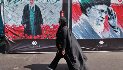 Una mujer pasa junto a una valla publicitaria con un retrato del ayatolá Ali Khamenei, líder supremo asesinado de Irán, mientras los dolientes se reúnen en la Gran Mosalla para rendirle sus últimos respetos al comienzo de sus ceremonias fúnebres en Teherán