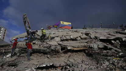 Voluntarios caminan sobre los escombros de un edificio derrumbado en Caraballeda, estado de La Guaira, Venezuela