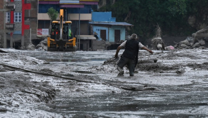 Un residente camina por una calle cubierta de barro tras unas inundaciones repentinas y un deslizamiento de tierra en Devighat, en el distrito nepalí de Nuwakot