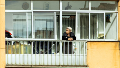 Mujer mayor en el balcón de su casa